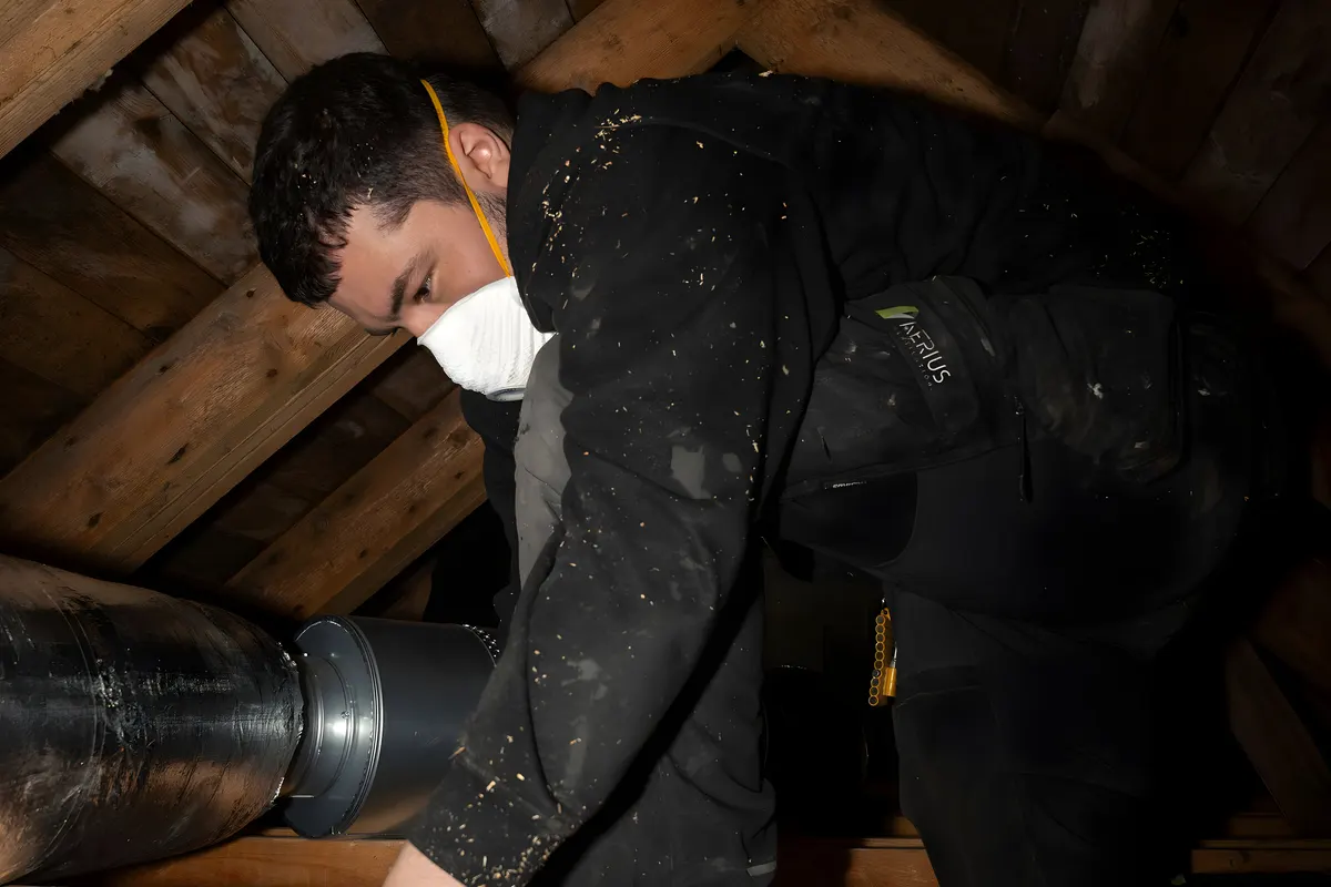 Ventilationstekniker med skyddsmask vid ventilationskanaler inför rengöring i Stockholm